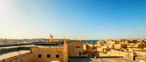 a view of the city of aleppo from the roofs of buildings at Kharmen A 1565s House with Seaviews in Birgu