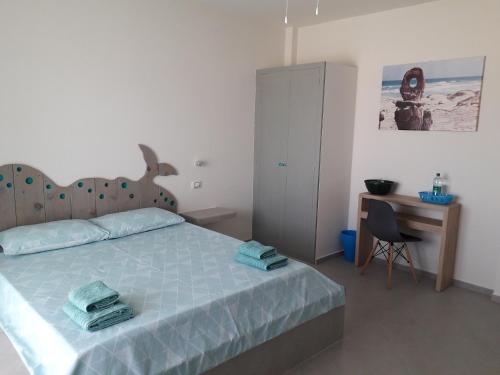 a bedroom with a bed and a desk and a chair at B&B Sereia Azul Boa Vista in Sal Rei