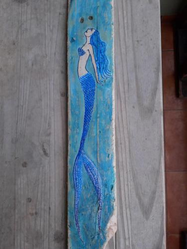 a painting of a mermaid on a surfboard at B&B Sereia Azul Boa Vista in Sal Rei