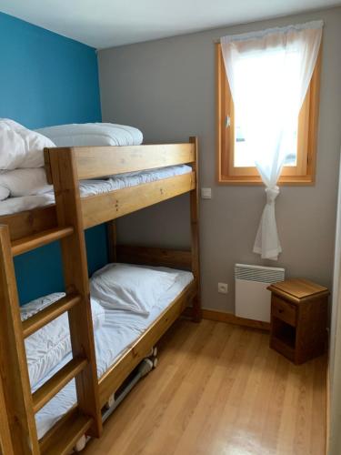 1 dormitorio con 2 literas y ventana en appartement au pied des pistes en La Chal