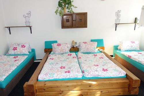two beds in a room with blue and pink pillows at chalupa in Hora Svatého Šebestiána