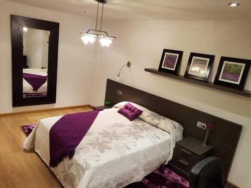 1 dormitorio con 1 cama con edredón morado y blanco en Apartamento XIABRE, VUT-Po-4181, en Vilagarcía de Arousa