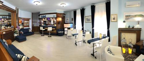 a hair salon with white chairs and a barber shop at Hotel Due Torri in Porto Azzurro