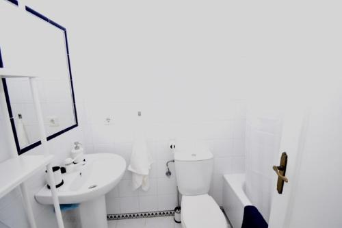een witte badkamer met een toilet en een wastafel bij Apartamento La Barrosa - Chiclana - Urb. Pinar Atlántico in Chiclana de la Frontera