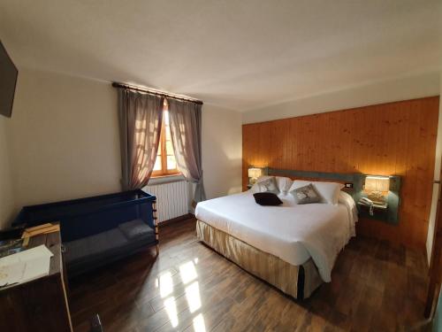 a hotel room with a large bed and a window at Locanda Il Rustichello in Mulazzo