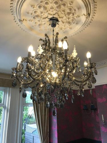 a chandelier hanging from a ceiling in a room at Amarillo Guesthouse in Bournemouth