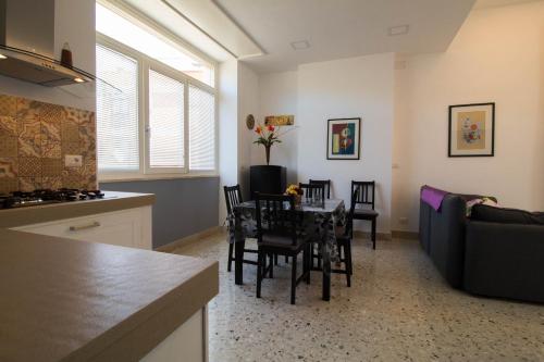 Casa Vacanze Belvedere في شيكلي: مطبخ وغرفة معيشة مع طاولة وكراسي