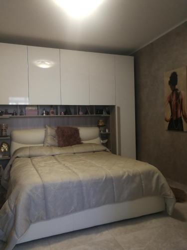 a bedroom with a large bed with white cabinets at Casa donna Fiorella tipica siciliana in Taormina