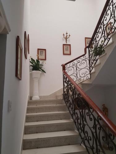 a staircase with a wrought iron railing and a plant at Dar is-Sliem in Tarxien