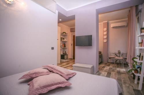 ein Schlafzimmer mit einem Bett mit rosa Kissen darauf in der Unterkunft CIVICO 69 AFFITTACAMERE in La Spezia
