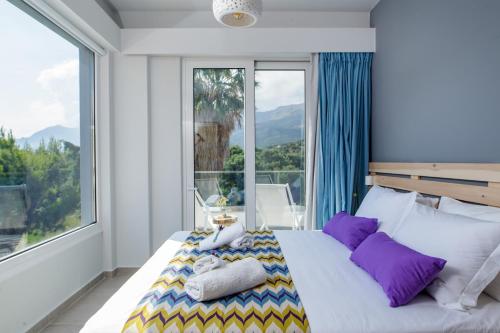 sypialnia z łóżkiem i dużym oknem w obiekcie IRIDA Guesthouse by the Pool w mieście Plakias