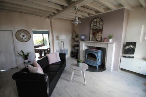 een woonkamer met een bank en een open haard bij Maison IZARO in Précy-Saint-Martin