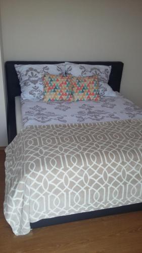 a bed with a white comforter and pillows at APARTAMENT NA DOBY - LUBIN in Lubin