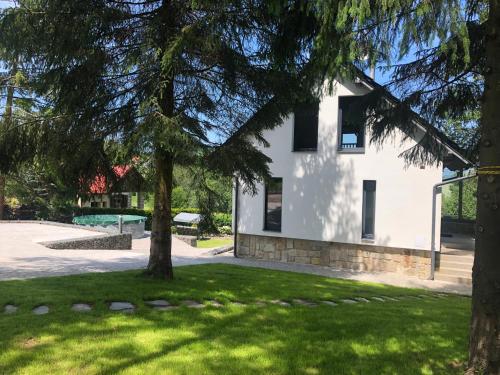 a white house with a tree in a yard at Chata Prachov**** in Jičín