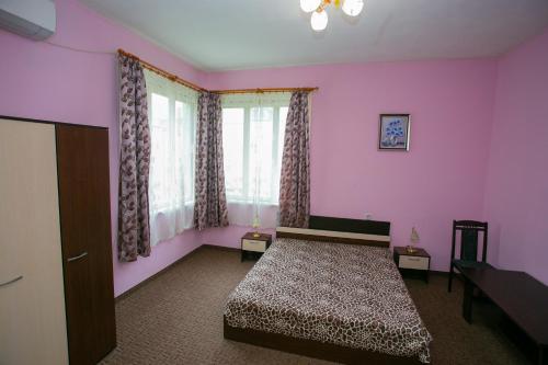 a bedroom with a bed in a pink room at Guest House Dobrudzha in Gabrovo