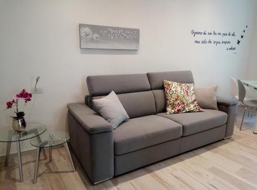 a gray couch in a living room with a table at GrigioPerla in Tavernerio