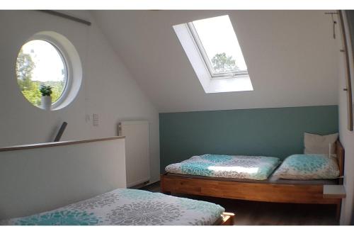 2 Betten in einem Zimmer mit Fenster und 2 Betten sidx sidx sidx sidx in der Unterkunft Finger's Hyggelig-Haus in Erbach