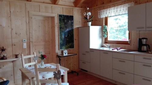 een keuken met witte kasten en een tafel en stoelen bij Ferienhaus Barbara in Ebenthal