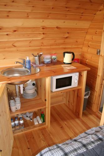 a kitchen with a sink and a microwave on a counter at Glamping at Spire View Meadow in Lincoln