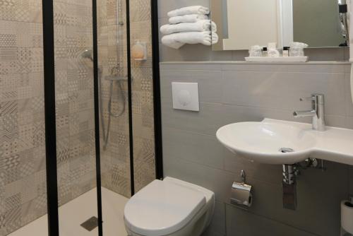 a bathroom with a toilet and a sink and a shower at Hôtel Duc De Padoue in Corte