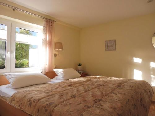 a bedroom with a bed with two pillows and a window at Ferienwohnung Graf Möwe in Ostseebad Karlshagen