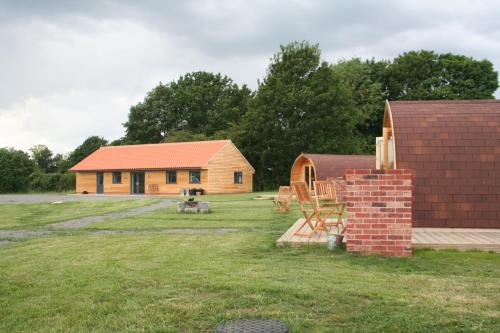 a house with a brick chimney in a yard at Glamping at Spire View Meadow in Lincoln