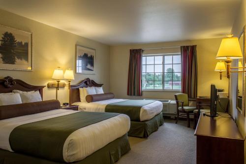a hotel room with two beds and a television at Boarders Inn & Suites by Cobblestone Hotels - Shawano in Shawano