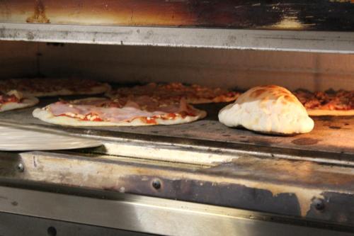 a group of pizzas cooking in an oven at Il Capriolo in Tavernelle