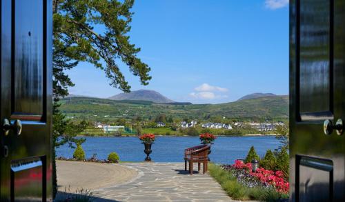 a view of a lake with a bench and flowers at Sheen Falls Lodge in Kenmare
