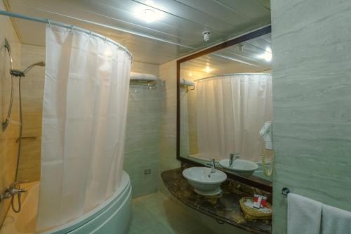 a bathroom with a sink and a shower with a mirror at Porto Marina Apartments By Amer-Group in El Alamein