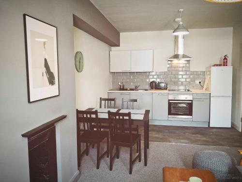 a kitchen and dining room with a table and chairs at Homely Serviced Apartments - Figtree in Sheffield