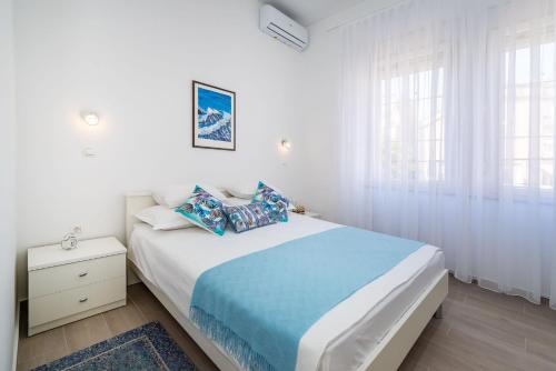 Habitación blanca con cama grande con almohadas en Apartment Zaramaktum en Zadar