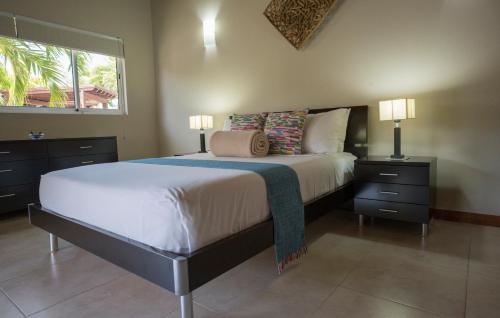a bedroom with a large bed with two lamps and a window at Costa Esmeralda Village in Palm-Eagle Beach