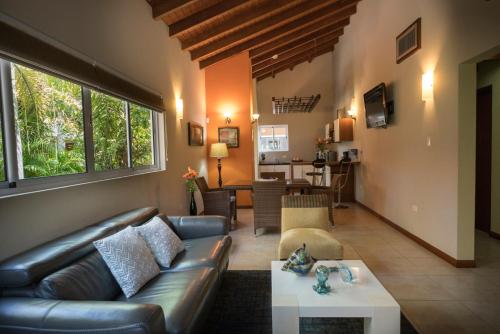 a living room with a leather couch and a table at Costa Esmeralda Village in Palm-Eagle Beach