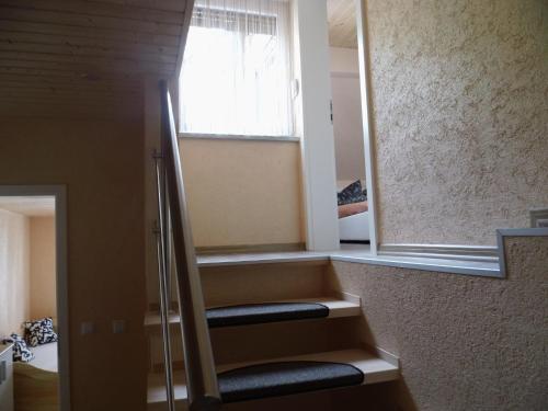 eine Treppe in einem Zimmer mit Fenster in der Unterkunft Hotel Restaurant Zum Valwiger Herrenberg in Valwig