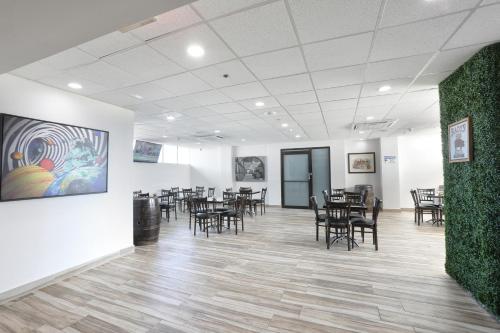 a room with tables and chairs and a painting on the wall at San Juan Airport Hotel in San Juan