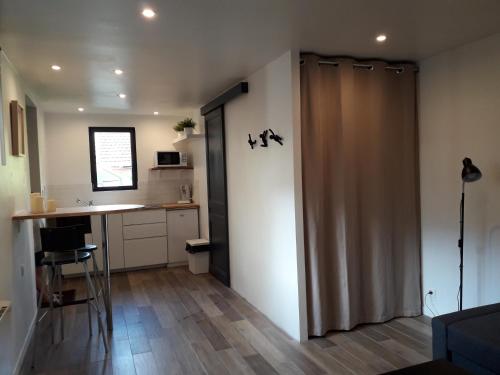 a room with a sliding door in a kitchen with a counter at Studio avec jardin et stationnement gratuit à Rouen in Rouen