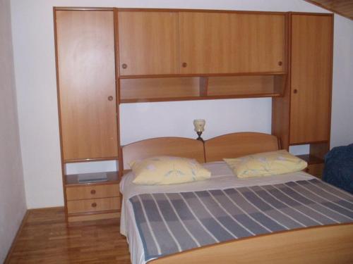 una camera con letto e testiera in legno di Apartman za 5 osoba a Medulin