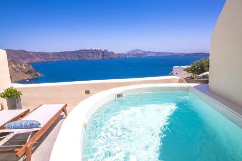 a swimming pool on a balcony with a view of the ocean at Aloia Villas in Oia