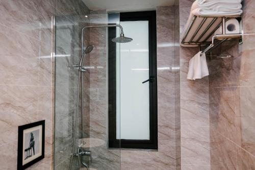 a shower with a glass door in a bathroom at Rosa Hanoi Hotel in Hanoi