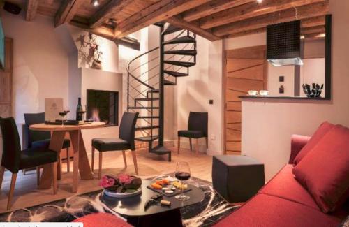 a living room with a red couch and a spiral staircase at Les Loges Annecy Vieille Ville in Annecy