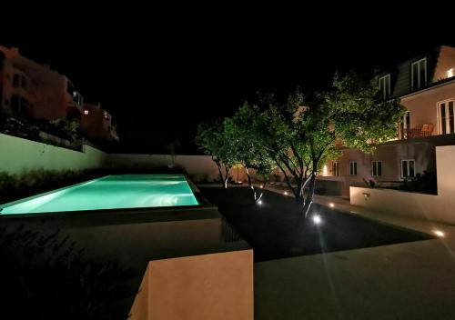 a swimming pool at night with lights at Casa René - Charming apartments in Almada