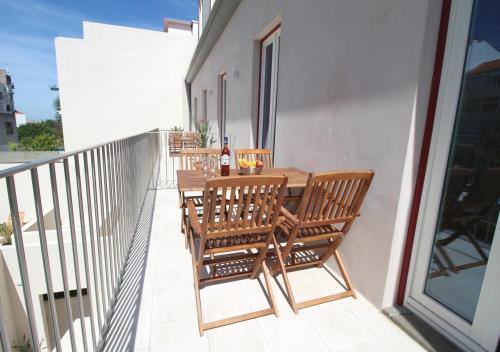 a balcony with a wooden table and chairs at Casa René - Charming apartments in Almada