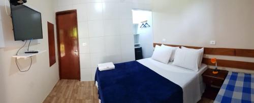 a hotel room with a bed and a tv at Casa do Maneco in Fernando de Noronha