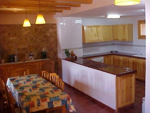 una cucina con bancone, tavolo e tavolo di Tossal del Maig a Barbará