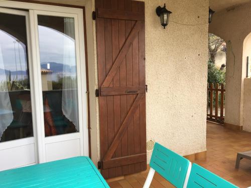 a door to a house with a blue bench at Vue mer panoramique plage 50m Porticcio Corse in Porticcio