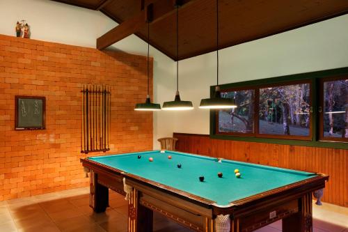a pool table in a room with a brick wall at Eco Resort Hotel Villa São Romão in Lumiar