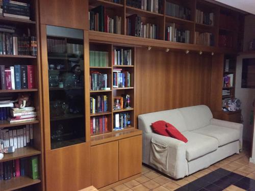 biblioteca con divano bianco e cuscino rosso di Relax e confort nella Perla dello Ionio a Soverato Marina