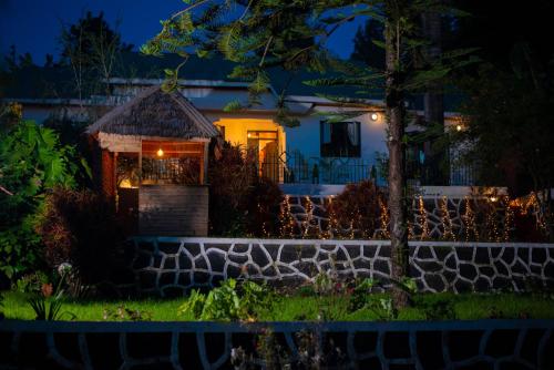 a house at night with a stone wall at Mambo Hideaway in Arusha