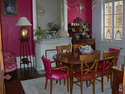 a dining room with a table and pink walls at AU 52 in Beauval